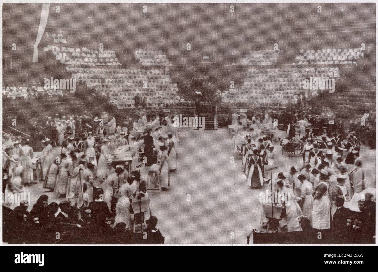 Scena dalle celebrazioni annuali delle case del Dr. Barnardo nella Royal Albert Hall. Qui nel display di formazione delle casalinghe, le giovani donne dimostrano il lavoro di lavanderia. Ogni anno nella Sala Albert è stata allestita una mostra del buon lavoro delle Case del Dott. Barnardo. Thomas John Barnardo (1845-1905) è una figura classica vittoriana, evangelica, imprenditoriale e filantropica. La sua crociata per 'scudere i bambini dalle strade' fu uno degli interventi sociali più conosciuti nell'ultima metà del XIX secolo. Foto Stock