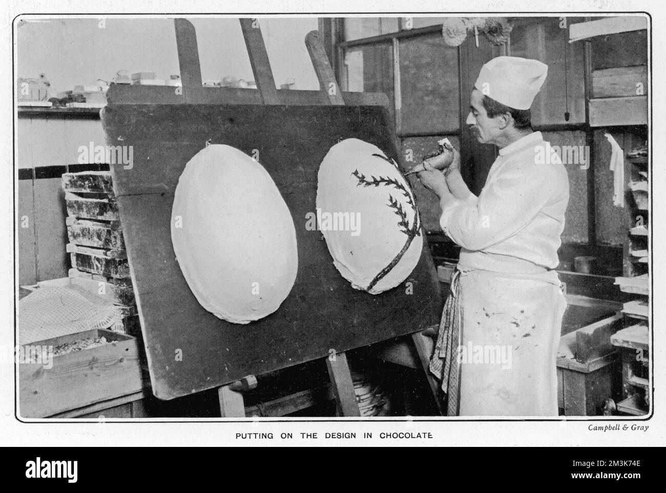 Operaio di Fuller's confections che decorano un grande uovo di Pasqua al cioccolato. Data: 1904 Foto Stock