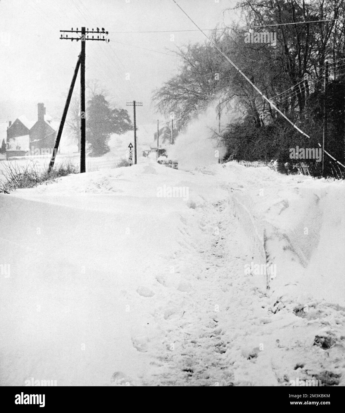 Un aratro da neve fa il suo percorso attraverso la neve profonda sulla collina di Westerham nel Kent su una strada che era stata impraticabile per giorni durante le condizioni molto fredde dell'inverno di 1963. Data: 1963 Foto Stock