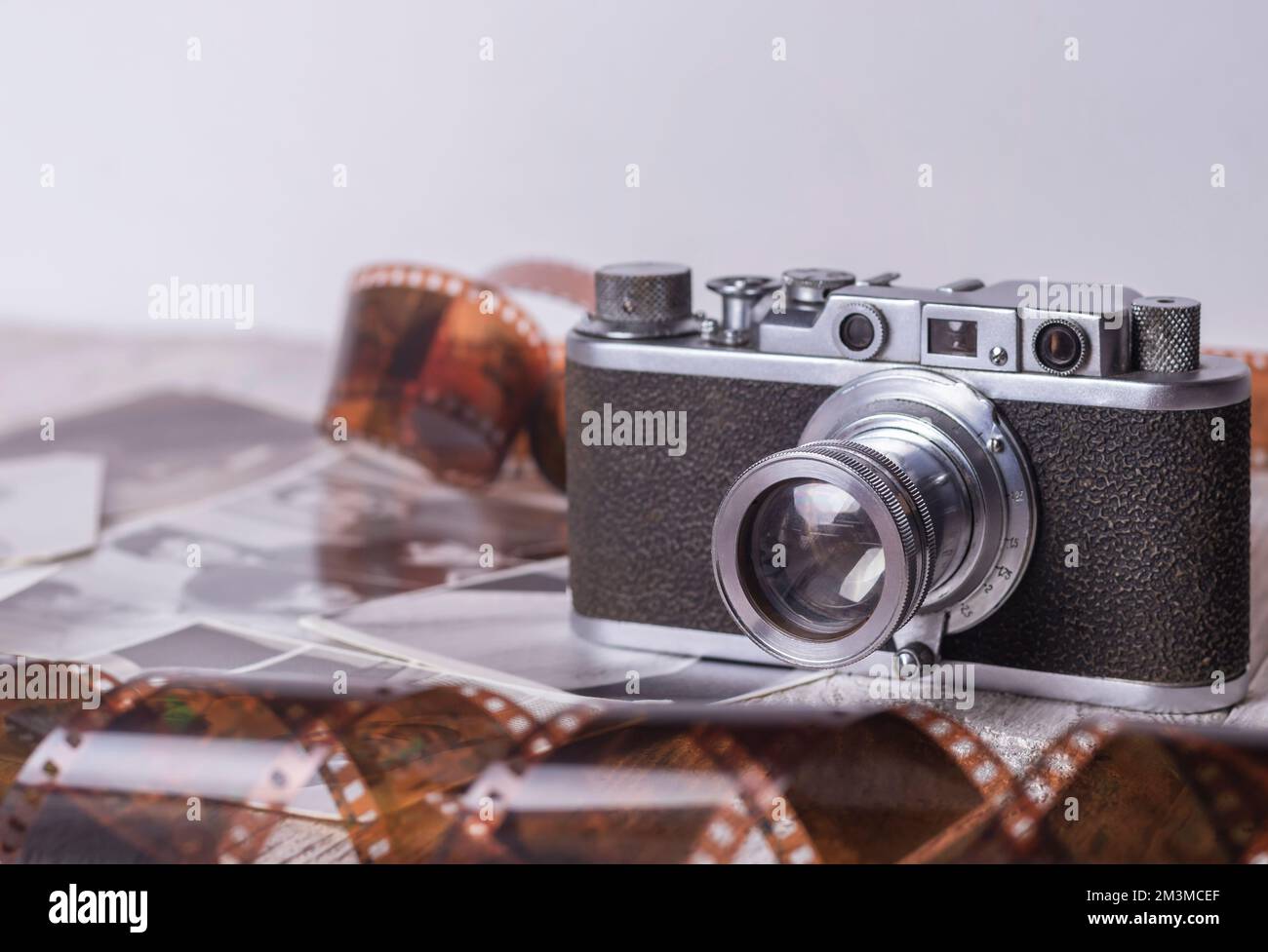 Una vecchia macchina fotografica antica si trova tra film fotografici e fotografie. Foto Stock