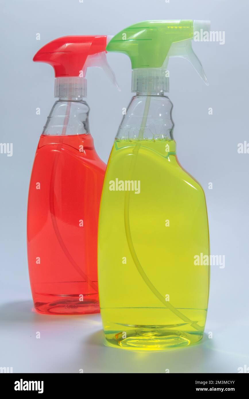 Due contenitori di detergente - rosso, verde. su sfondo bianco Foto Stock