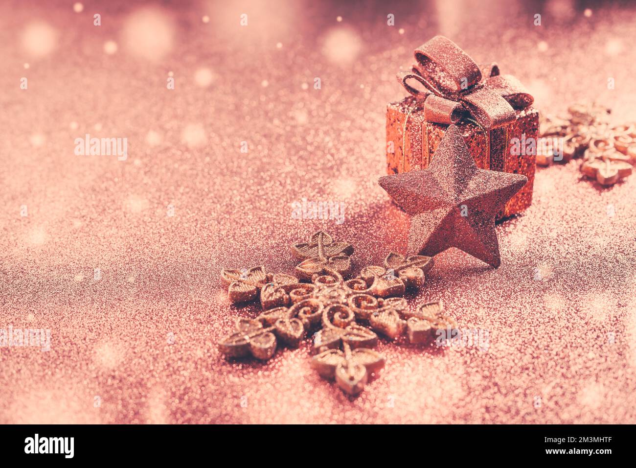 Regalo di Natale con ornamenti e palle. Sfondo glitter sfocato. Foto Stock