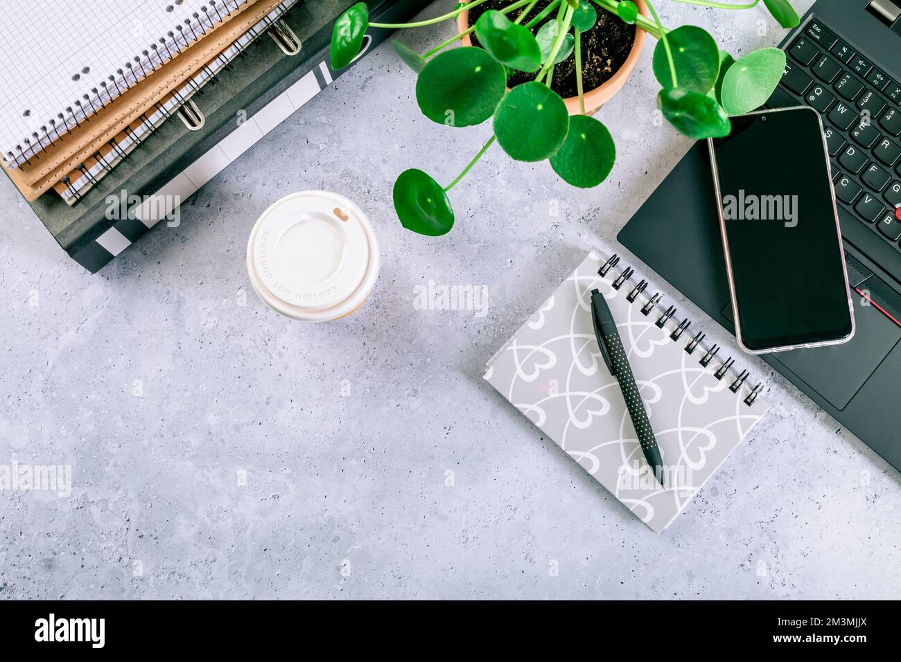 Moderno tavolo da ufficio con computer portatile, smartphone e altri accessori con tazza di caffè Foto Stock