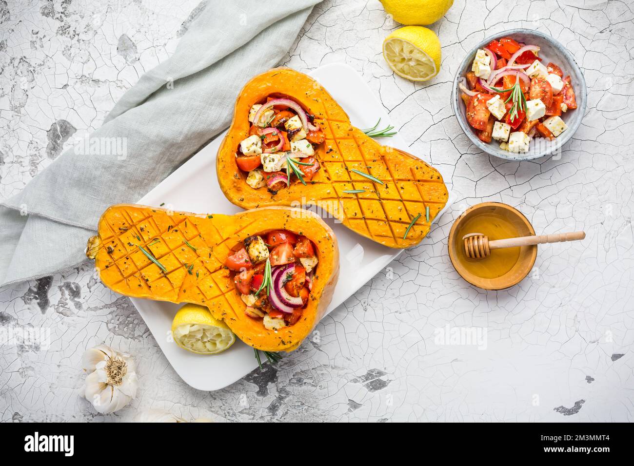 Zucca arrosto a metà con farcitura di verdure piccanti e formaggio feta Foto Stock