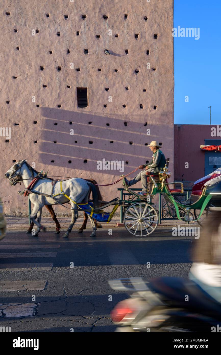Cavallo e carrozza passando attraverso le mura della città alla porta Nuova a Marrakech, Marocco. Popolare tra i turisti lasciati in pullman per i tour di Marrakech. Foto Stock