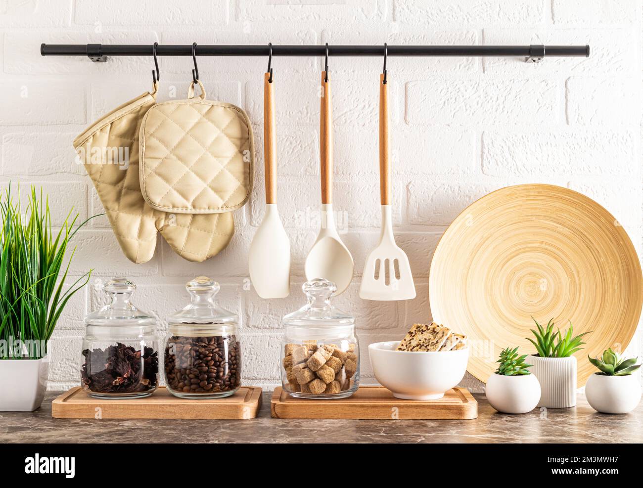 vista frontale della parte del piano cucina con vasetti di vetro per stoccaggio, una ciotola con biscotti e piante in vaso. muro di mattoni con ringhiera Foto Stock