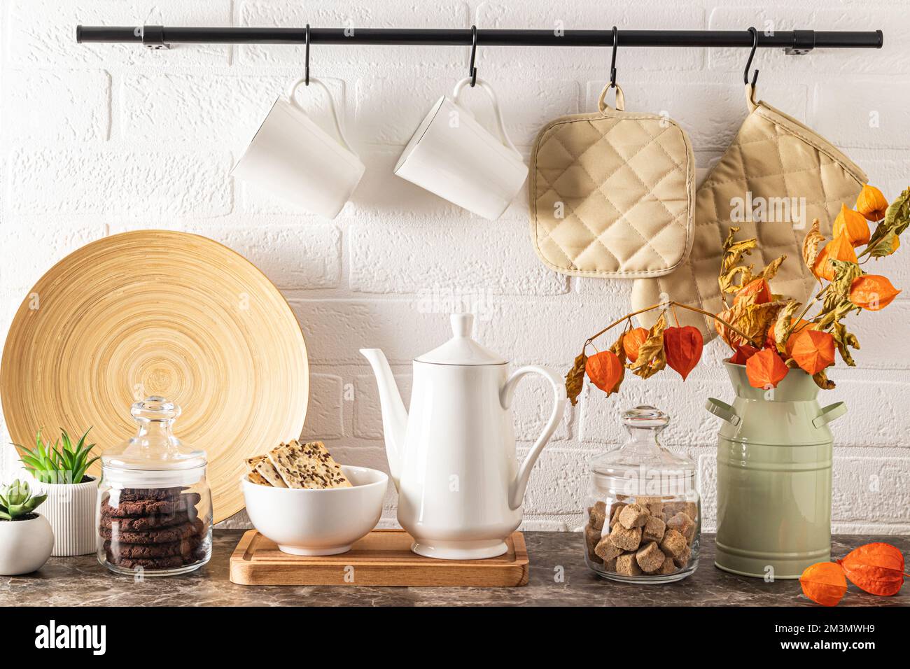 caffettiera in porcellana bianca, lattine di zucchero e chicchi di caffè, biscotti in grani in una ciotola. cucina sfondo moderno Foto Stock