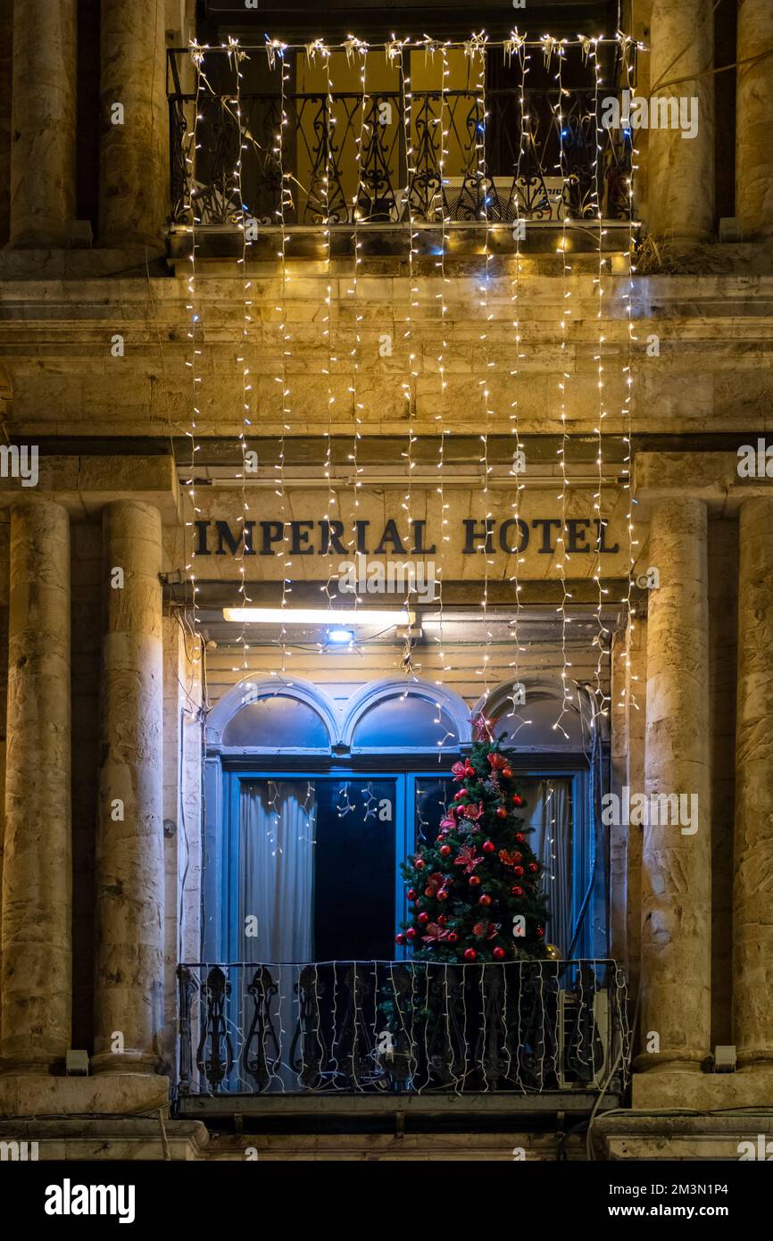 Albero di Natale esposto in un balcone del nuovo Hotel Imperiale costruito in stile neoclassico europeo nel 1889, di proprietà della Chiesa Greco Ortodossa situata in Piazza Omar Ibn al-Khattab vicino a porta Jaffa n Gerusalemme, Israele Foto Stock