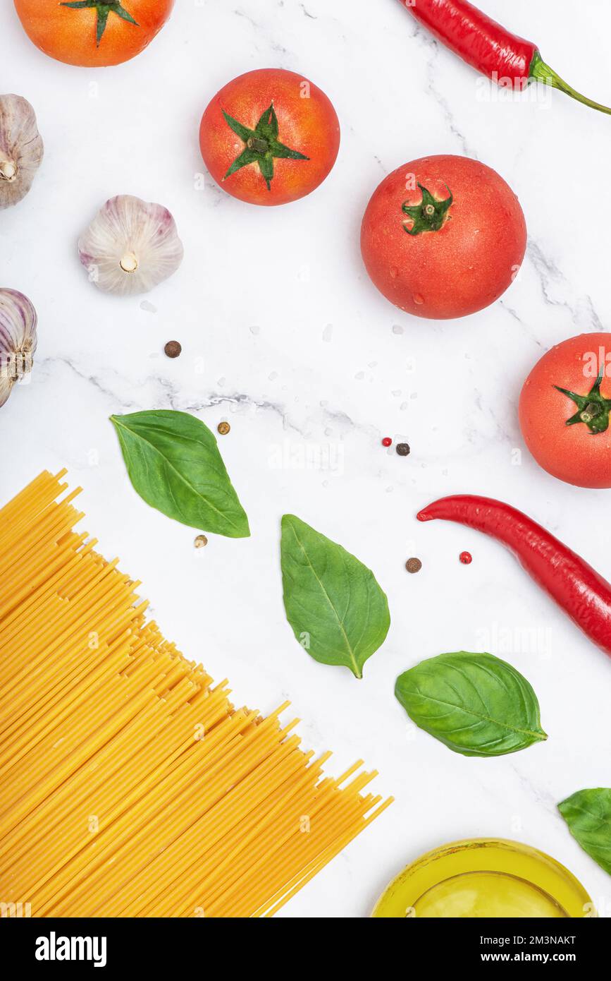 sfondo culinario con pasta e verdure. Preparazione del cibo. Ingredienti per la pasta. Verticale Foto Stock