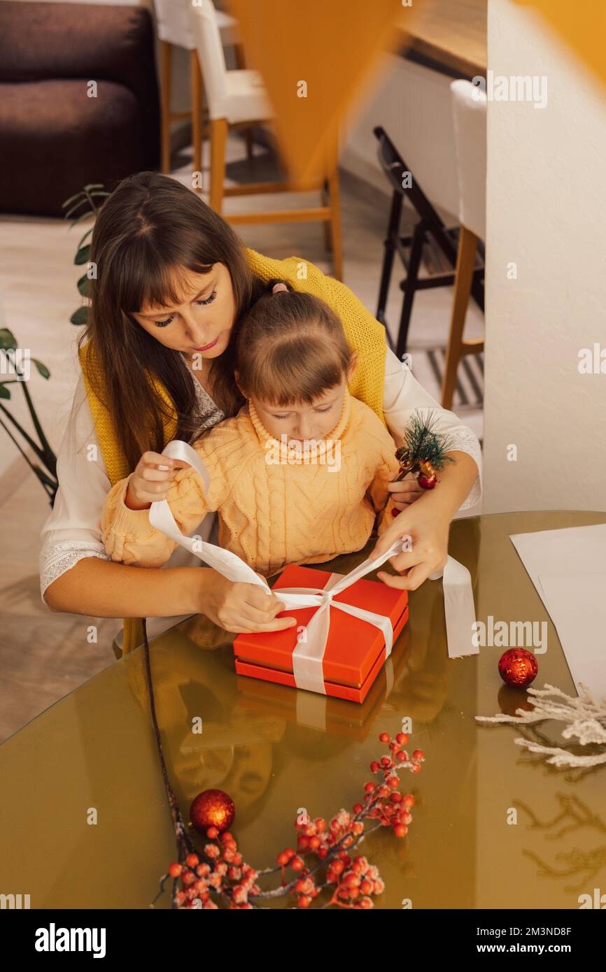 Una famiglia felice madre e bambino pacchetto regali di Natale. Stile di vita. Regali per il nuovo anno. Regali di Natale fatti in casa Foto Stock