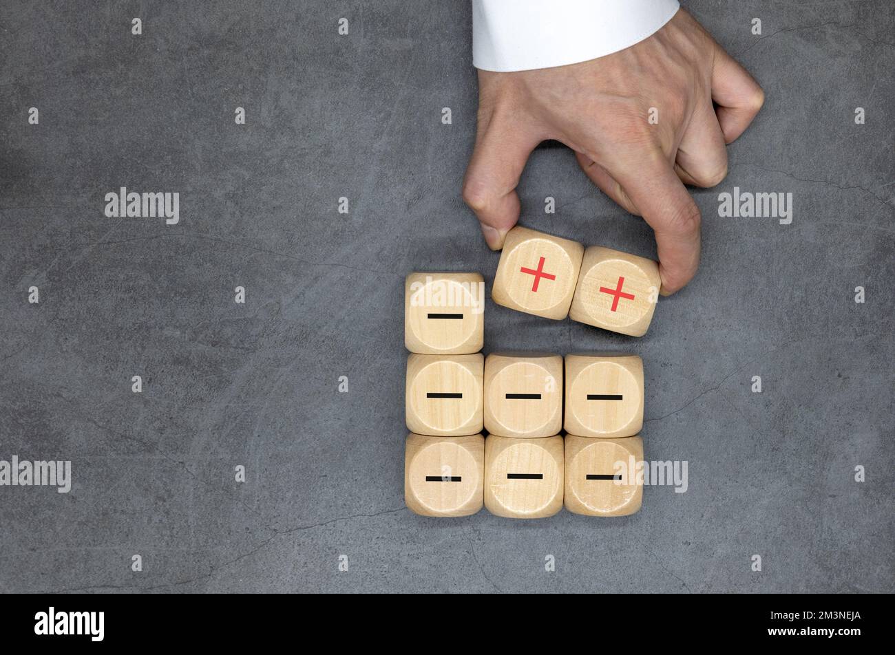 Icone più e meno su cubi di legno. Separare il negativo dal positivo, rimuovendo le debolezze o negatività, il pensiero positivo, il feedback negativo Foto Stock