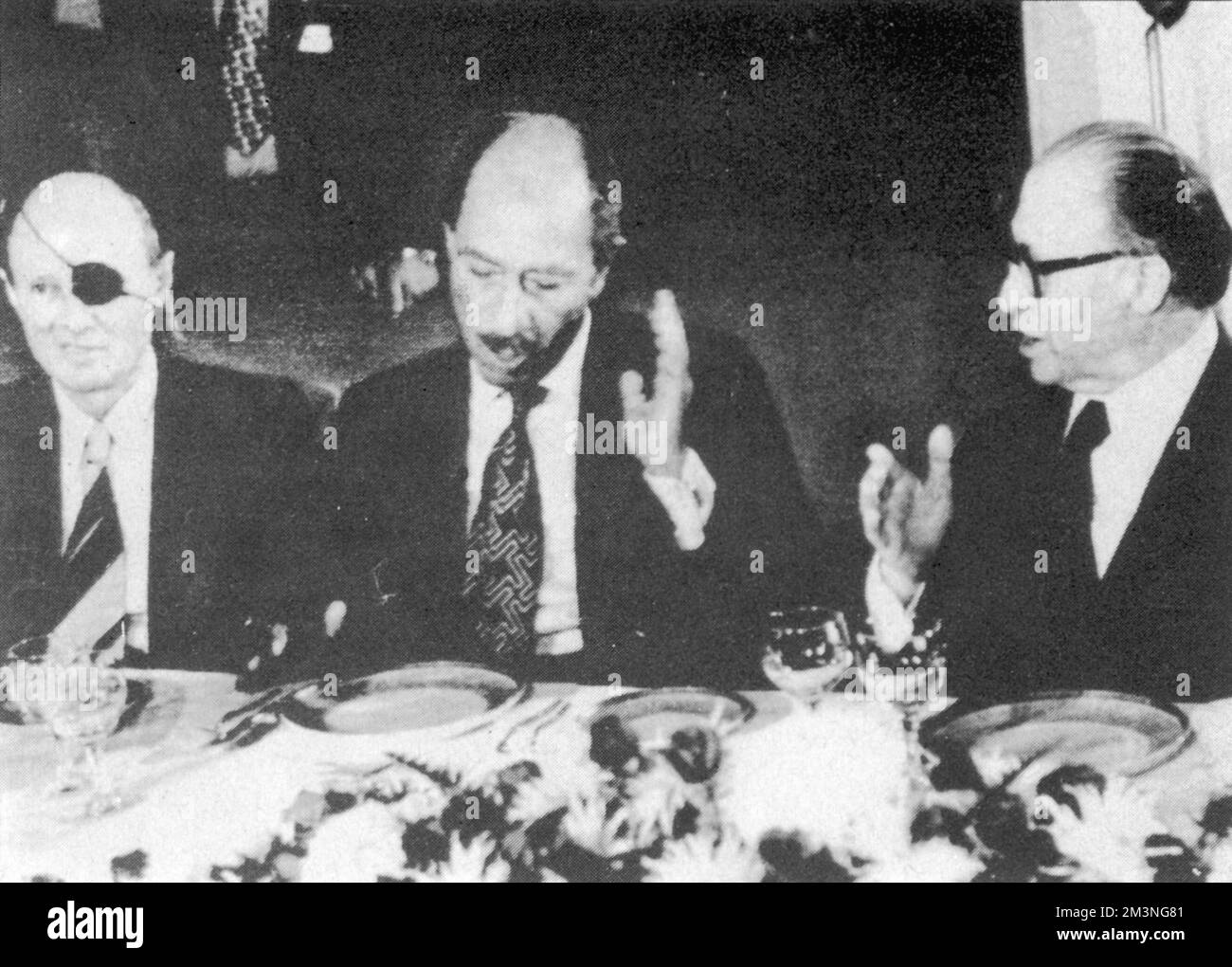 Anwar Sadat d'Egitto (1918-1981) in una cena di Stato in suo onore, seduto tra Moshe Dayan (1915-1981) e il primo ministro israeliano Menachem Begin (1913-1992). Sadat divenne il primo leader arabo a mettere piede in Israele nei suoi 29 anni di esistenza quando arrivò a Tel Aviv all'inizio della sua visita di due giorni. Data: Novembre 1977 Foto Stock