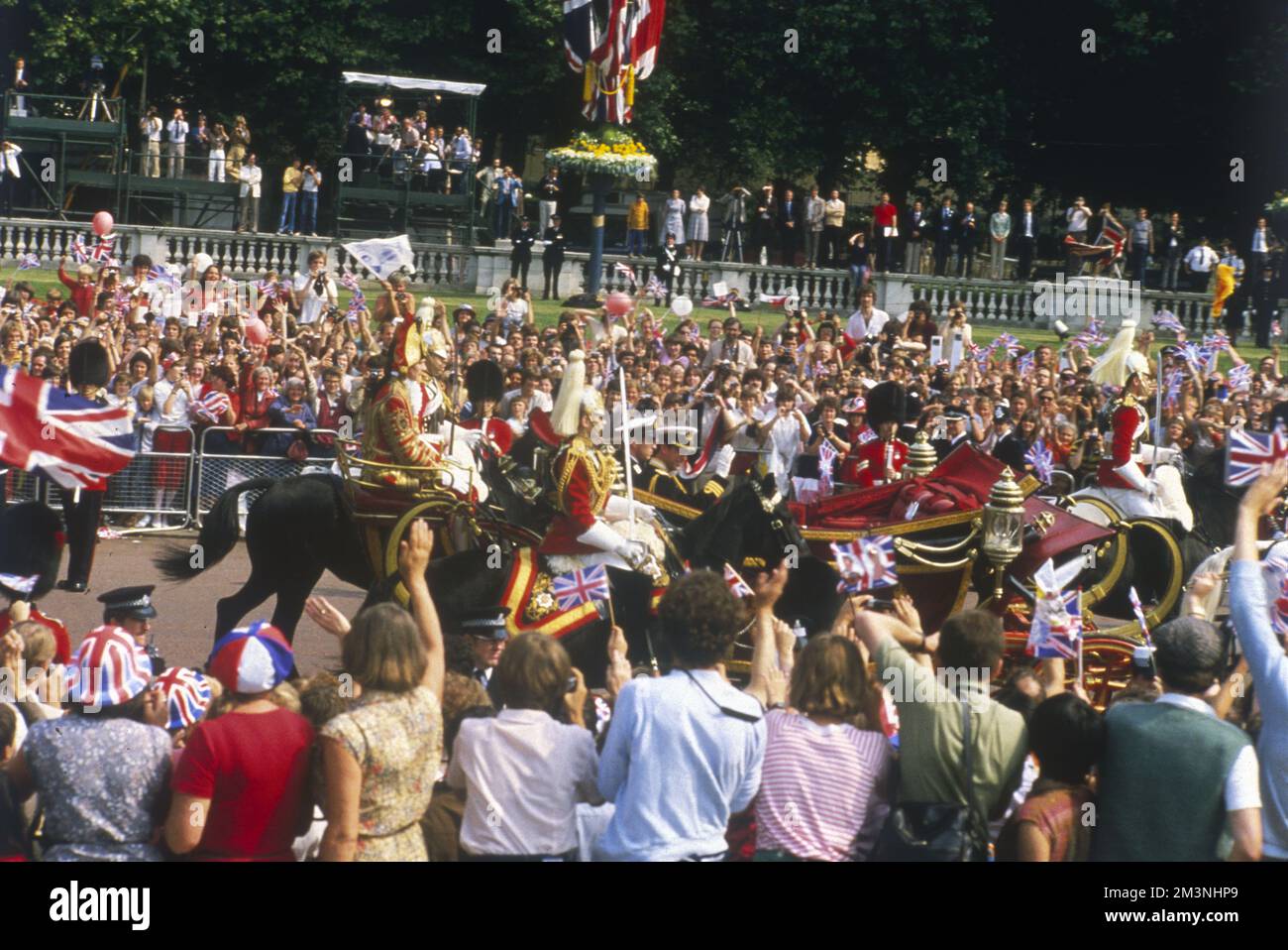 Le strade di Londra sono fiancheggiate da una folla di tifosi, mentre il principe Carlo e il suo Best Man, fratello minore Andrew, passano in una carrozza aperta sulla strada per St Pauls. Data: 29 luglio 1981 Foto Stock