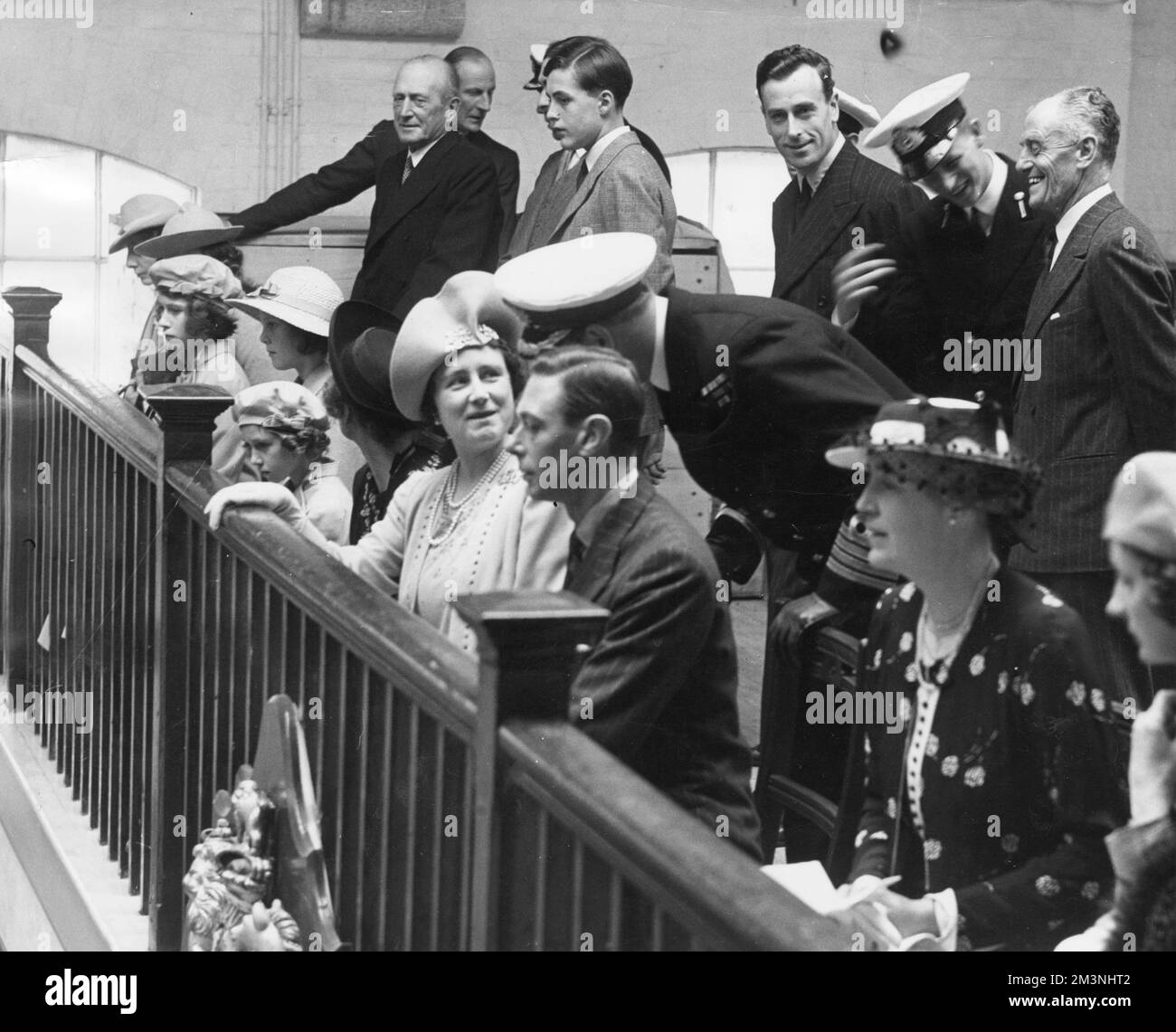 Probabilmente la prima occasione in cui la regina Elisabetta II e il suo futuro marito, il principe Filippo di Grecia, furono fotografati insieme, al Dartmouth Naval College il 22 luglio 1939. La principessa di 13 anni può essere vista guardando solenne seduto all'estrema sinistra della foto. Accanto a lei c'è la principessa Margaret, e poi la regina con il re Giorgio VI. Dietro di loro si può vedere il cugino del re Lord Louis Mountbatten e accanto a lui, ridendo e gesticulando, è il principe Filippo. Data: 1939 Foto Stock