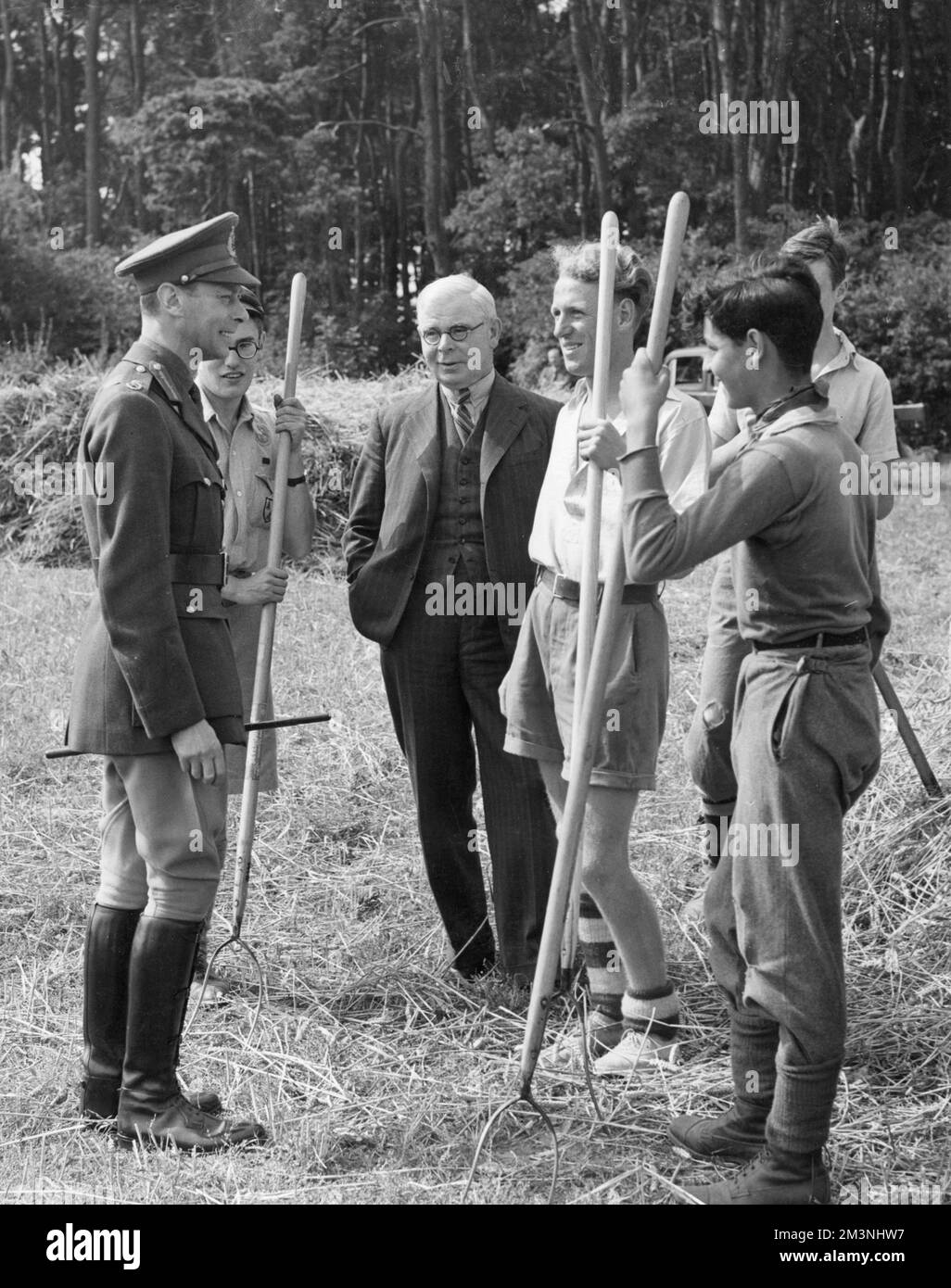 Re Giorgio vi che parla con gli aiutanti agricoli in tempo di guerra Foto Stock