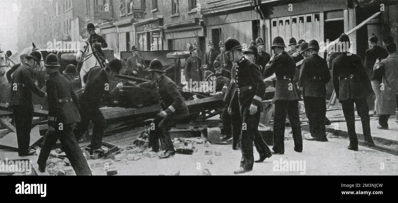 La polizia smantella una barricata istituita da dimostranti antifascisti nell'East End di Londra, parte della protesta contro la marcia proposta da Sir Oswald Mosley e dalla sua Unione britannica dei fascisti. La protesta ha avuto successo, la marcia è stata deviata dalla zona. Data: 4 ottobre 1936 Foto Stock