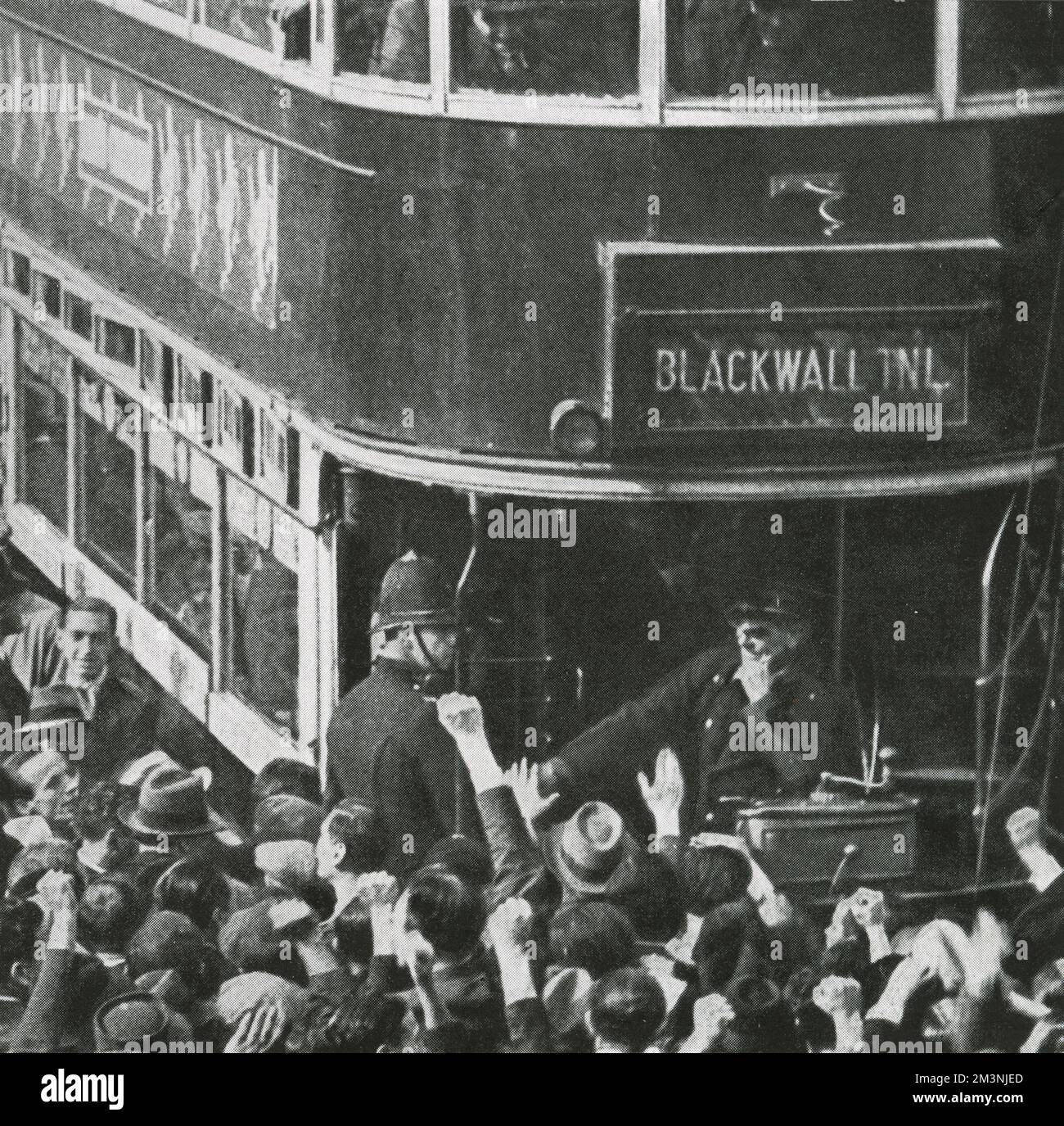 Folle antifasciste, alcune salutano il pugno comunista, si riuniscono intorno a un tram nell'East End di Londra. Una folla molto numerosa si è riunita per protestare contro la marcia proposta da Sir Oswald Mosleys British Union of Fascists. La marcia è stata deviata dalla polizia per evitare il confronto. Data: 4 ottobre 1936 Foto Stock