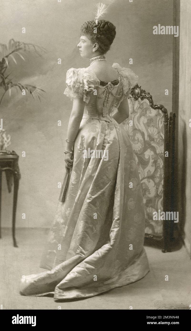 Studio ritratto della Regina Maria (1867 - 1953), forse quando ancora Principessa maggio di Teck. mostra una vista posteriore con lei indossando un elegante abito da sera e tenendo un ventilatore. Data: c.1890 Foto Stock