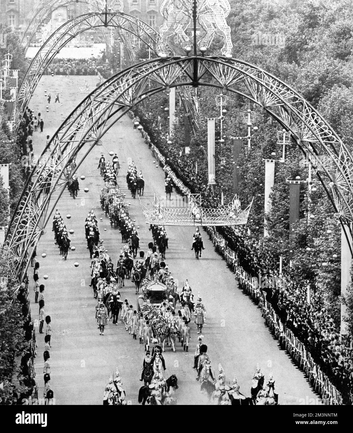 Il pullman di Stato dorato passa sotto i grandi archi e le corone dorate che decorano il Mall, Londra durante la processione all'Abbazia di Westminster per l'incoronazione della Regina Elisabetta II nel giugno 1953. Data: 1953 Foto Stock