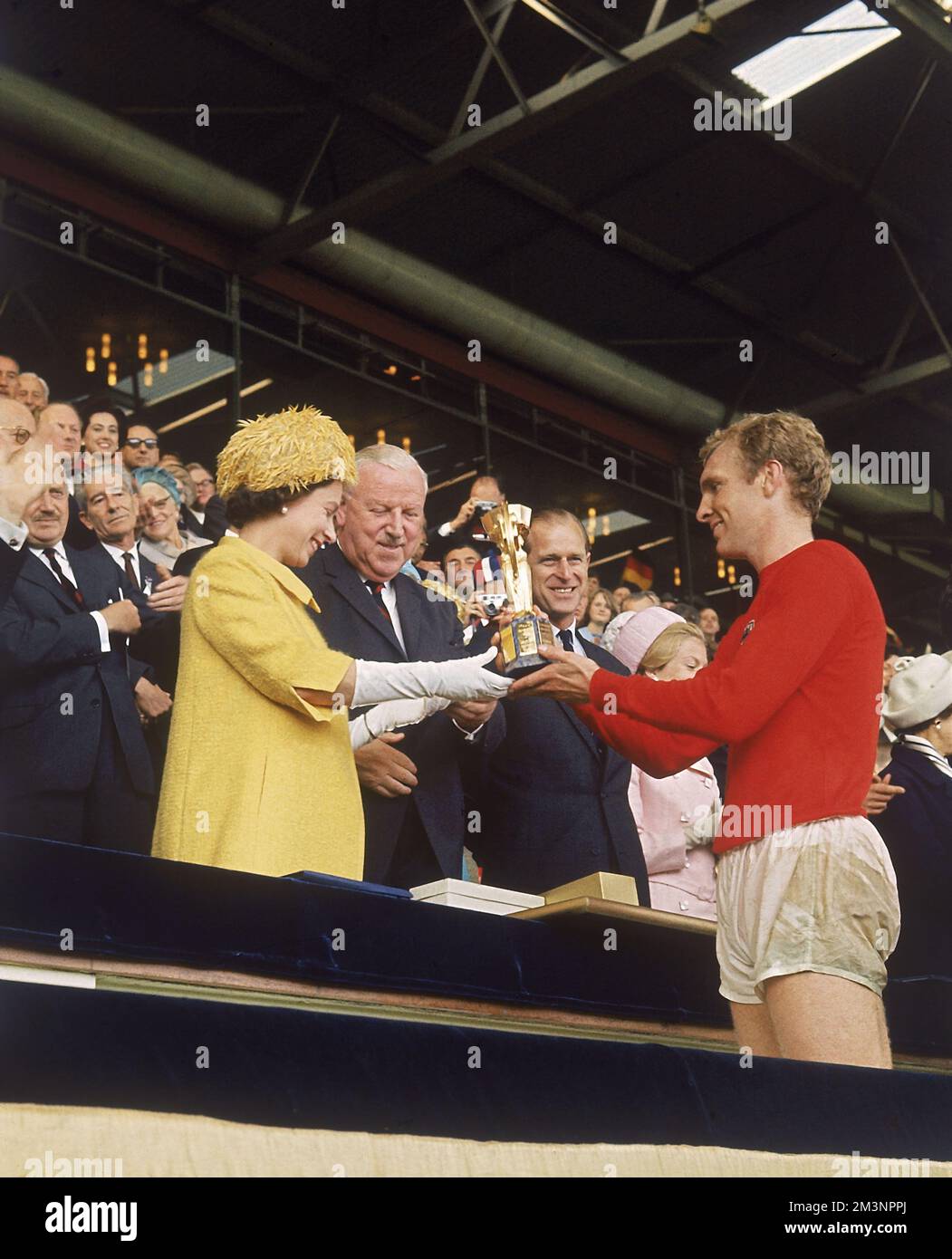 Finale di Coppa del mondo 1966. La regina Elisabetta II presenta il trofeo di Coppa del mondo (Jules Rimet Trophy) al capitano d'Inghilterra Bobby Moore, vincitore dopo aver vinto la partita contro la Germania Ovest allo Stadio di Wembley, Londra, il 30 luglio 1966. Data: 1966 Foto Stock