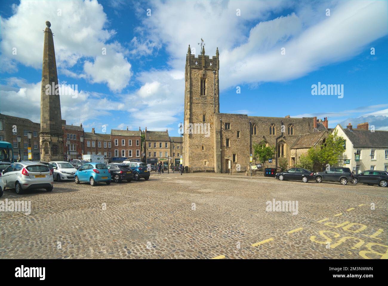 Richmond; antico centro cittadino acciottolato. Guardando a nord, l'Obelisco e la Chiesa della Santissima trinità, Richmond, North Yorkshire Inghilterra Regno Unito Foto Stock