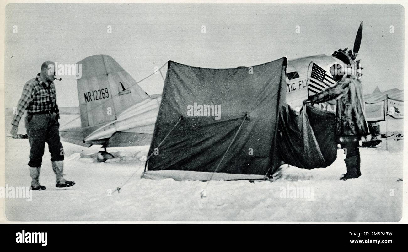Lincoln Ellsworth (a sinistra) e Herbert Hollick-Kenyon (a destra), il suo pilota, preparandosi per il loro volo trans-antartico da Dundee Island in un aereo 'Polar Star', volando 2000 miglia attraverso l'Antartico alla Baia delle balene, sul Mare di Ross. Il volo antartico si fermò prematuramente, a causa della carenza di carburante, e dovette essere salvato dalla nave da ricerca britannica Royal Discovery II, che fu trovata dopo sette settimane, a 420 miglia di distanza, a Little America. Data: 1935 Foto Stock