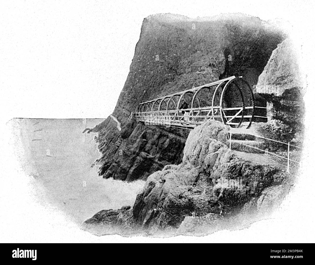 Il sentiero della scogliera di Gobbins a Islandmagee, Contea di Antrim, Irlanda del Nord. Questa immagine mostra la costa rocciosa con ponte e sentiero che sono stati costruiti lungo il lato della scogliera. Il sentiero panoramico costiero è stato costruito dall'ingegnere Berkeley Deane Wise. Data: 1907 Foto Stock