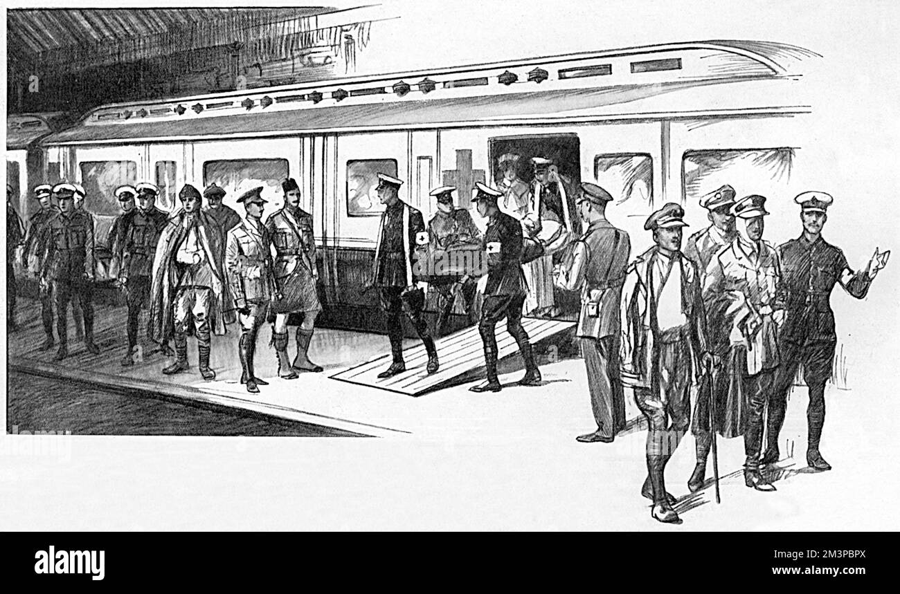 Arrivo di un treno ospedaliero in una stazione ferroviaria di Londra che mostra delle rampe vicino alle porte attraverso le quali i portatori dell'ambulanza trasportano una valigia 'COTa' su una barella. Durante la prima guerra mondiale, i treni per ambulanze arrivarono tutti i giorni alla stazione termini della South Coast e gli occupanti furono distribuiti ai numerosi ospedali militari di Londra. Oltre a incontrare treni a Charing Cross, Waterloo, Clapham Junction e altrove, ha intrapreso casi di rimozione da un ospedale all'altro e a case convalescenti nel paese. Data: 1916 Foto Stock