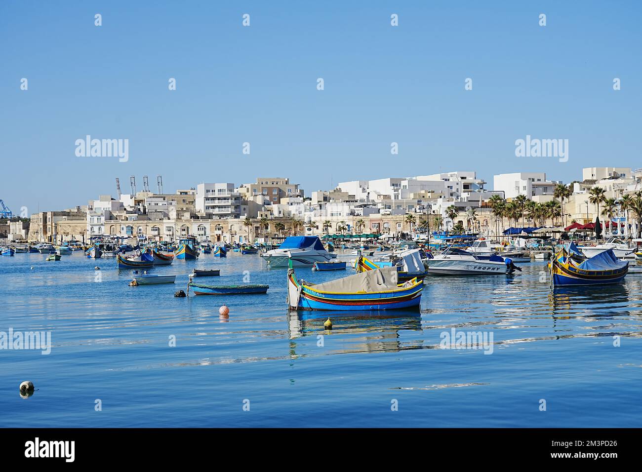 MARSAXLOKK, MALTA il 2022 maggio: Barche da pesca in città europea, cielo azzurro nel caldo giorno di primavera soleggiato. Foto Stock