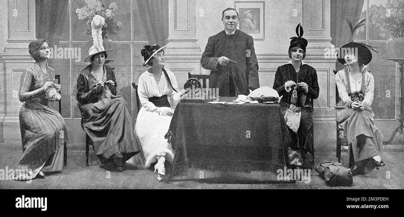Una scena da 'Business As usual' una nuova rivisita all'Ippodromo di Londra con un vicario che si rivolge a un gruppo di donne che sono maglieria e cucire comfort per le truppe. Data: 1914 Foto Stock
