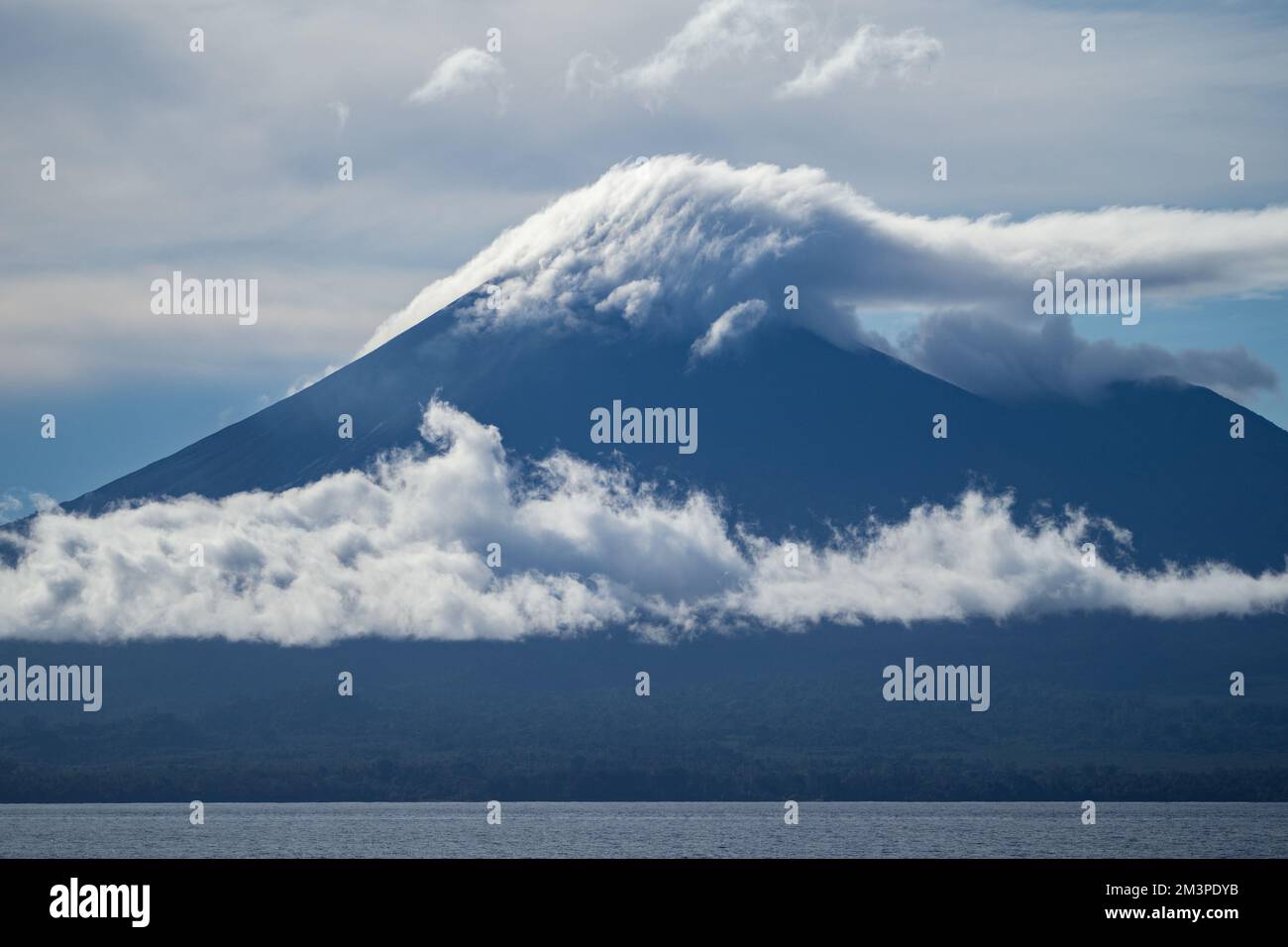 Nuvole che si formano sopra il vulcano nell'Oceano Pacifico meridionale - anello di fuoco Vulcano in Papua Foto Stock