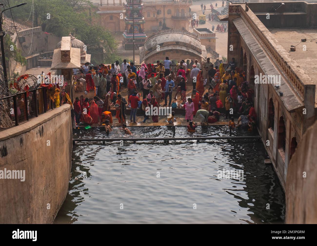 Pellegrini indiani che hanno un bagno in tempio Galtaji aka tempio scimmia, Rajasthan, Jaipur, India Foto Stock