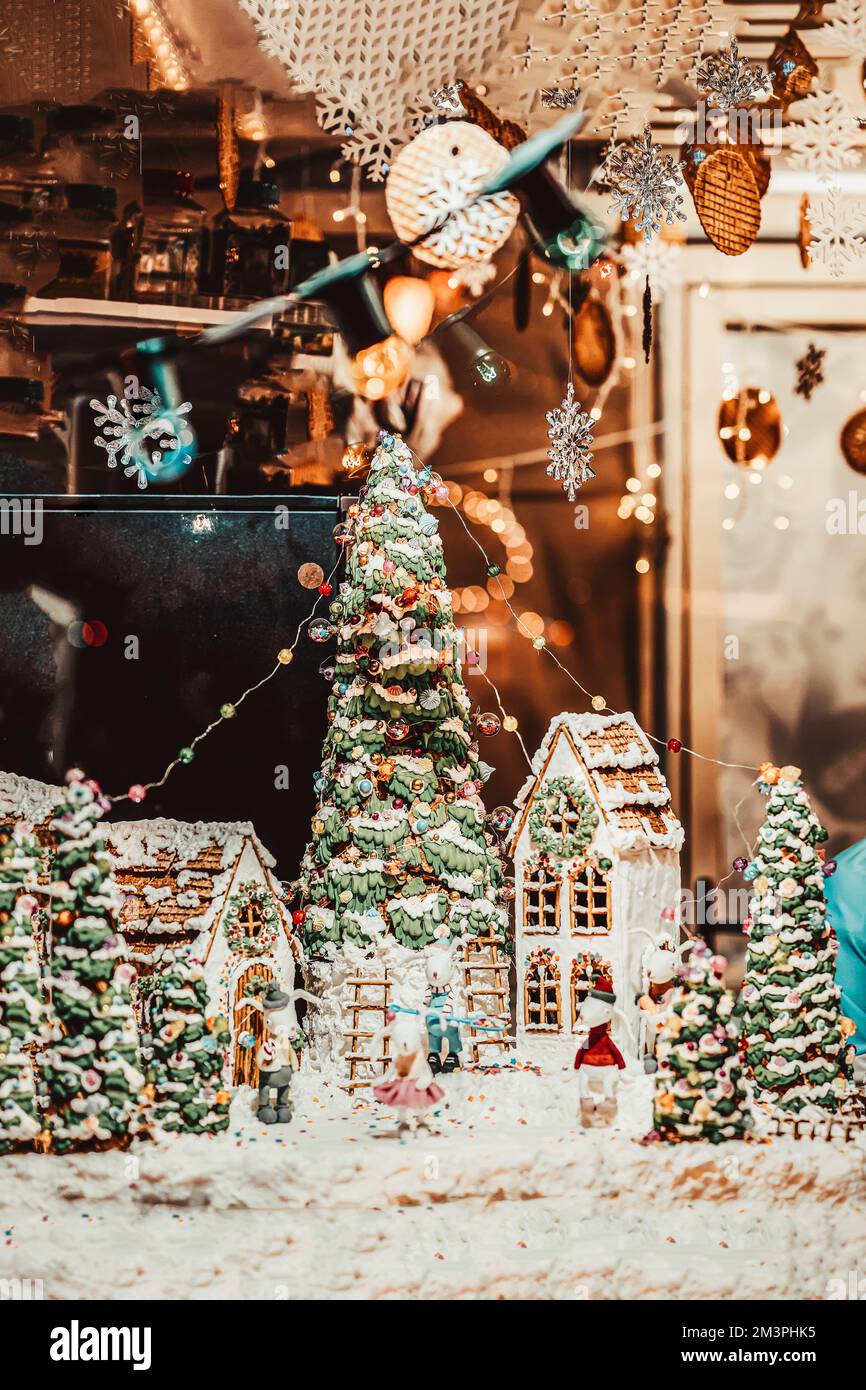 Case di pan di zenzero, alberi di Natale decorati, altre decorazioni con ghirlande in vetrina urbana Foto Stock