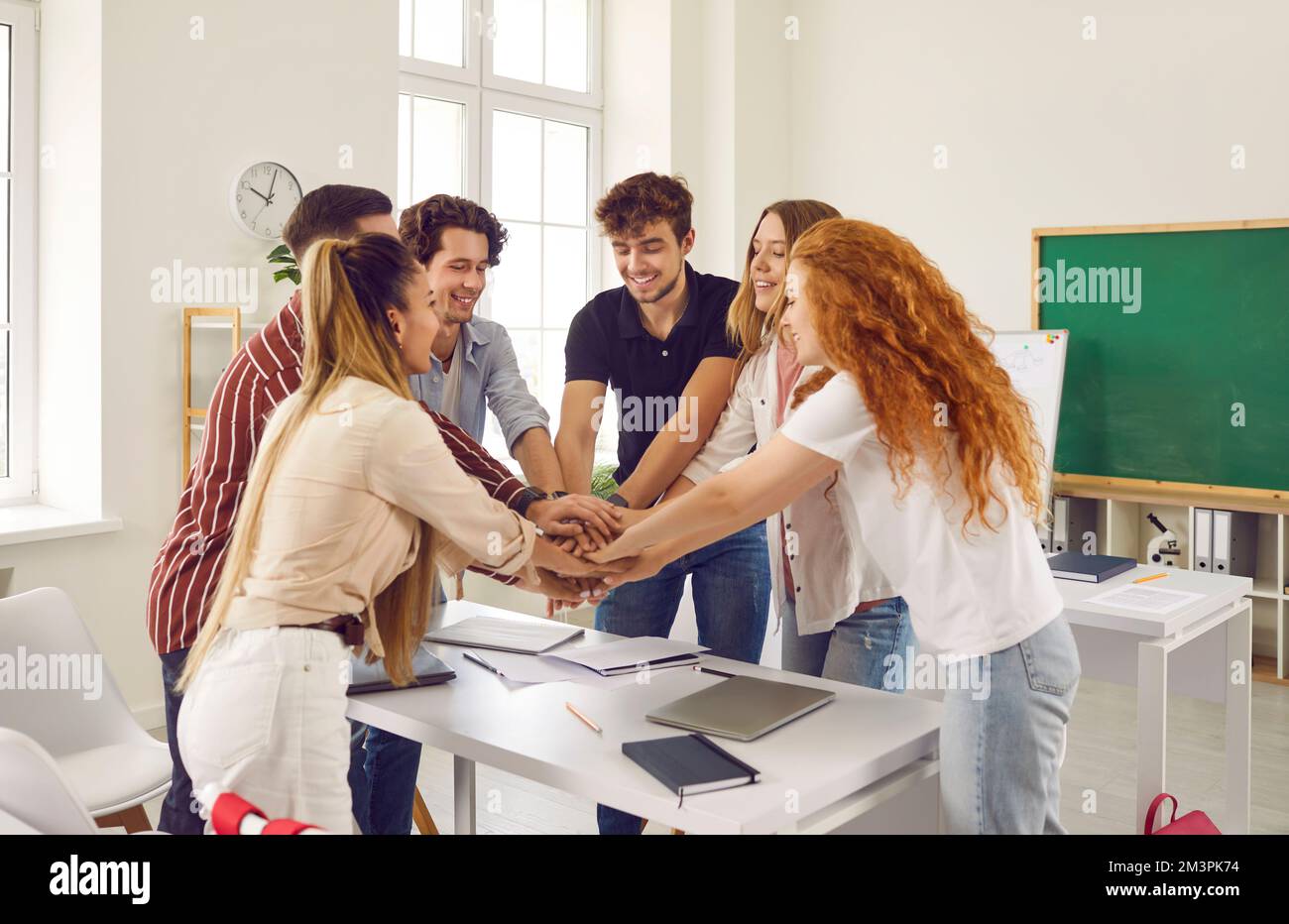 Il compagno di classe tiene le mani insieme, il lavoro di squadra di partenariato e la risoluzione riuscita dei problemi nell'università. Foto Stock