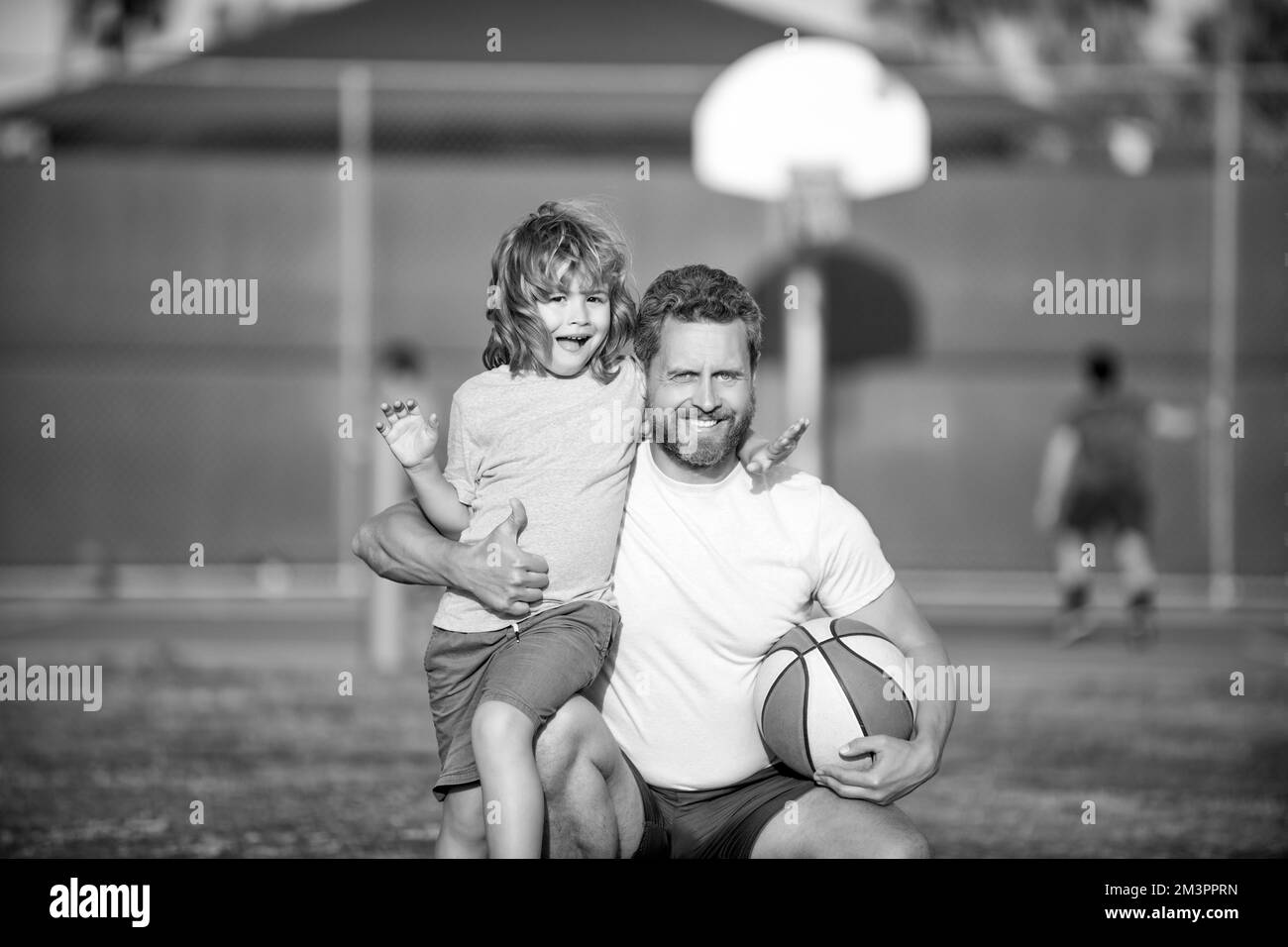 felice papà e figlio che gioca a basket con palla all'aperto, famiglia Foto Stock