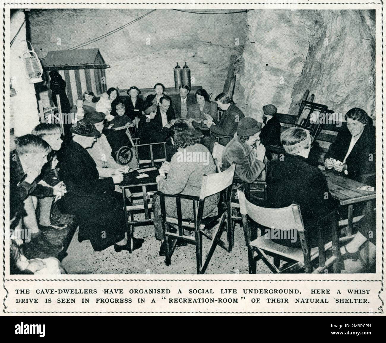 Grotte di Chislehurst durante la seconda guerra mondiale. Gli abitanti delle grotte hanno organizzato una vita sociale sotterranea. Qui un whist drive è visto in corso in una sala ricreativa del loro rifugio naturale. 1944 Foto Stock