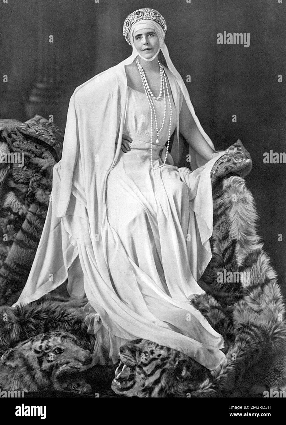 Regina Maria di Romania (1875 - 1938), la consorte di Re Ferdinando i di Romania. Figlia del principe Alfred, duca di Edimburgo e quindi nipote della regina Vittoria. La propensione di Marie per il dramma e il vestito flamboyant è riflessa in questo ritratto in cui posa su due tappeti di pelle di tigre. Data: 1931 Foto Stock