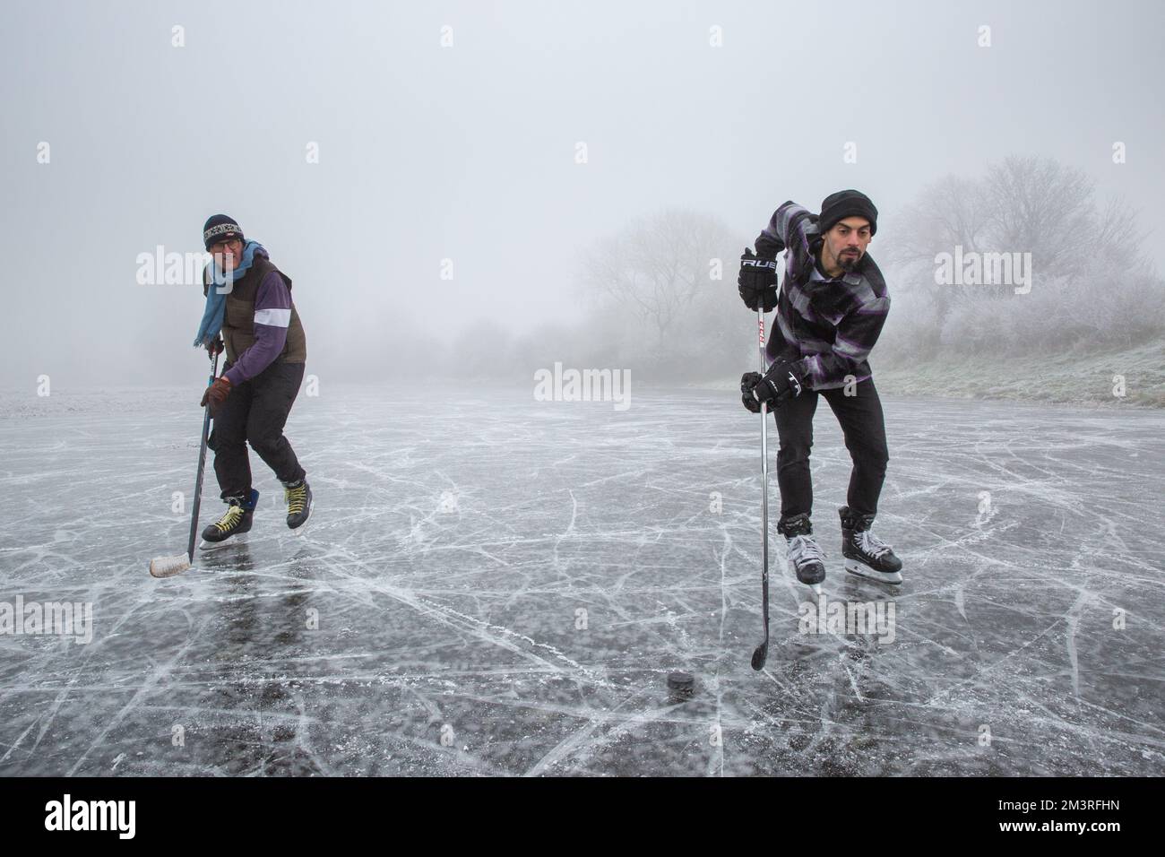 Foto datata dicembre 11th mostra le persone che giocano hockey su ghiaccio sul ghiaccio Cambridgeshire Fens vicino Ely su una mattina nebbia Domenica come il weath congelamento Foto Stock