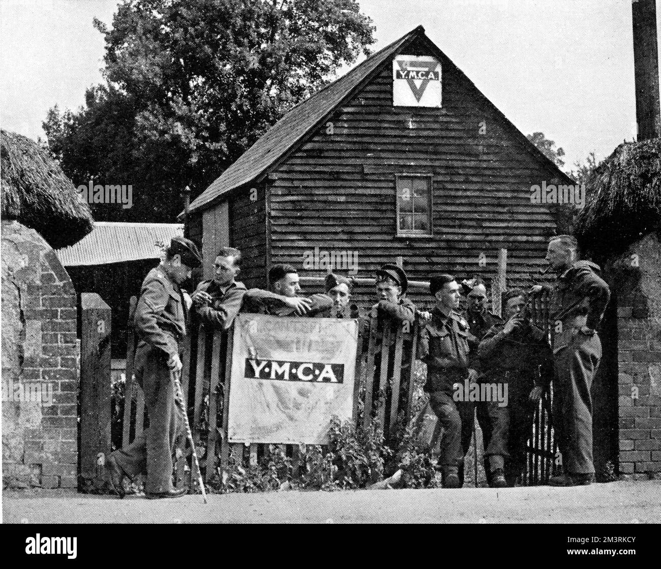 Soldati in Codford St. Mary, Wiltshire, si riunì fuori da una mensa, un tempo luogo di incontro dell'Istituto delle Donne e un cortile. 1940 Foto Stock
