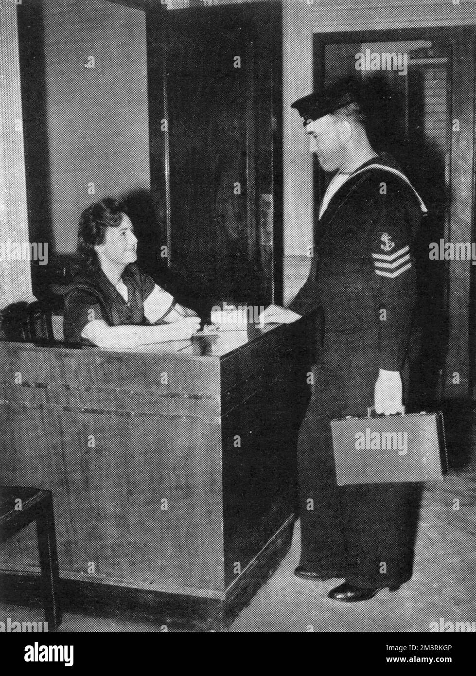 Un marinaio effettua il check-in presso l'ostello Y.M.C.A., ex ristorante Gatti's on the Strand, Londra. Gatti's fu presa in consegna dallo Y.M.C.A. come mensa per le truppe di stanza in città. 1940 Foto Stock