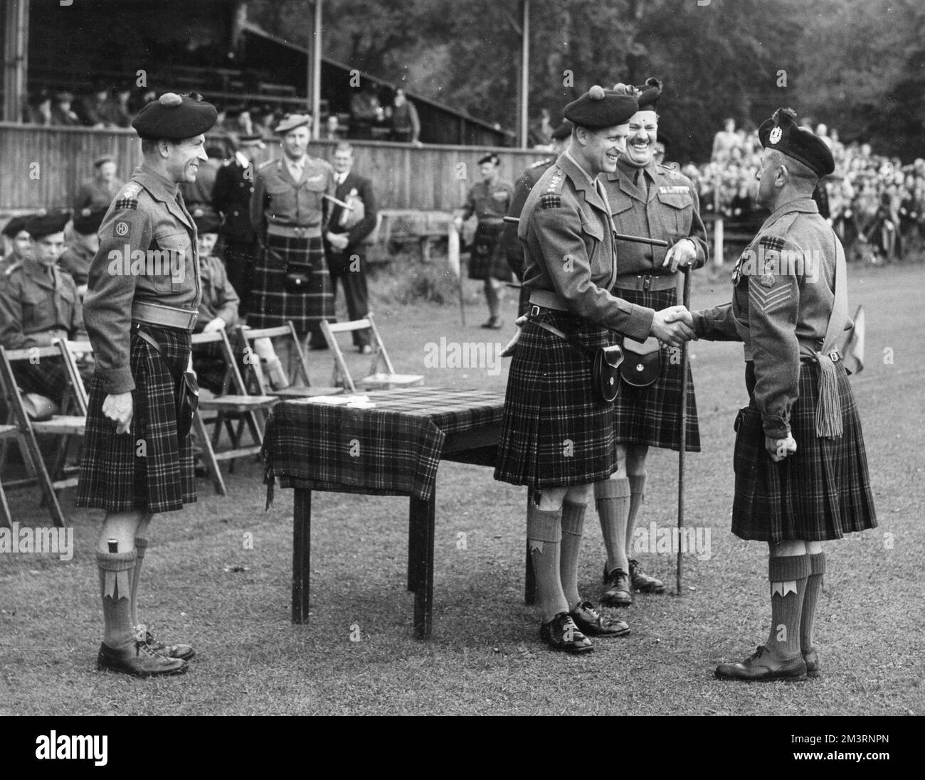 Il principe Filippo, Duca di Edimburgo, visita il battaglione delle regine Cameron Highlanders del 4th e del 5th a Stobs Camp, Hawick nel 1955. La foto mostra il Duca che presenta una medaglia di lunga durata e buona condotta al C.S.M. McDonald. Data: 1955 Foto Stock