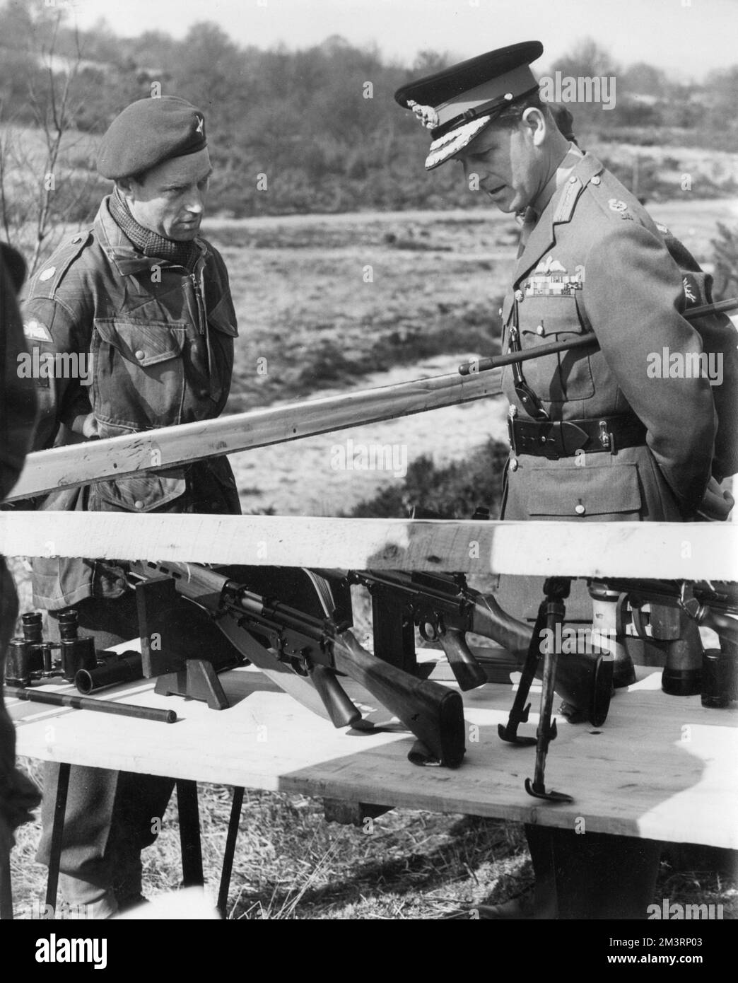Il principe Filippo, Duca di Edimburgo, ispezionando le armi dei paracadutisti in una stazione dimostrativa di addestramento a Caesars Camp, Aldershot, il 15 aprile 1955, quando visitò il 16th° gruppo della Brigata indipendente del paracadute. Data: 1955 Foto Stock