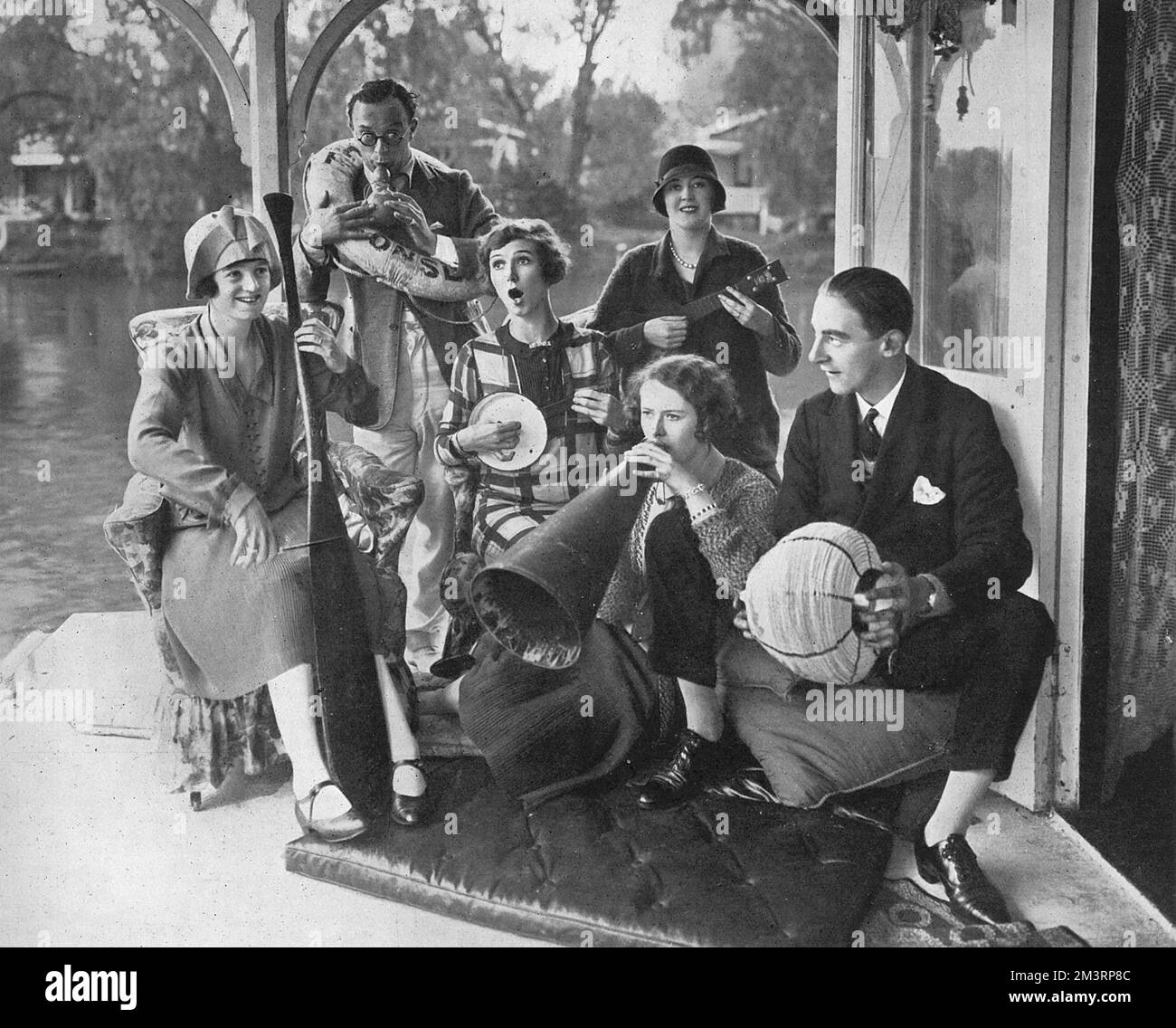 Foto di Leslie Henson che intrattiene la compagnia "Tell me More" Foto Stock