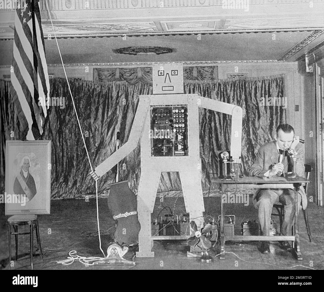 Il Sig. R. J. Wensley della Westinghouse Electric and Manufacturing Company che gestisce un 'uomo meccanico' o robot che, in risposta a segnali e note pronunciate su un pipe di lancio, ha svelato un ritratto di George Washington. La Graphic commenta la macchina, "ritiene che un giorno il lavoro del mondo possa essere portato avanti da automatoni che non penseranno mai di colpire" e continua a mettere in dubbio la loro utilità alla luce della recente industrializzazione meccanizzata che porta alla disoccupazione in America. Il robot è stato chiamato Herbert Televox, il primo dei numerosi robot basati su brevetti rilasciati da Foto Stock