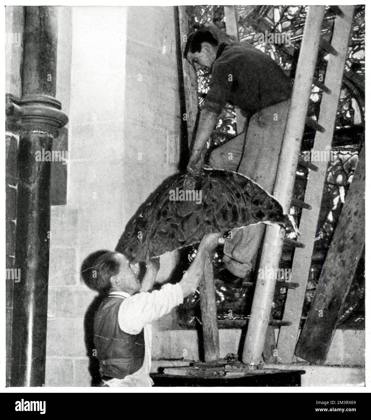 Operai che rimuovono preziose vetrate dalle finestre della Cattedrale di Canterbury in seguito allo scoppio della guerra nel settembre 1939. Data: 1939 Foto Stock