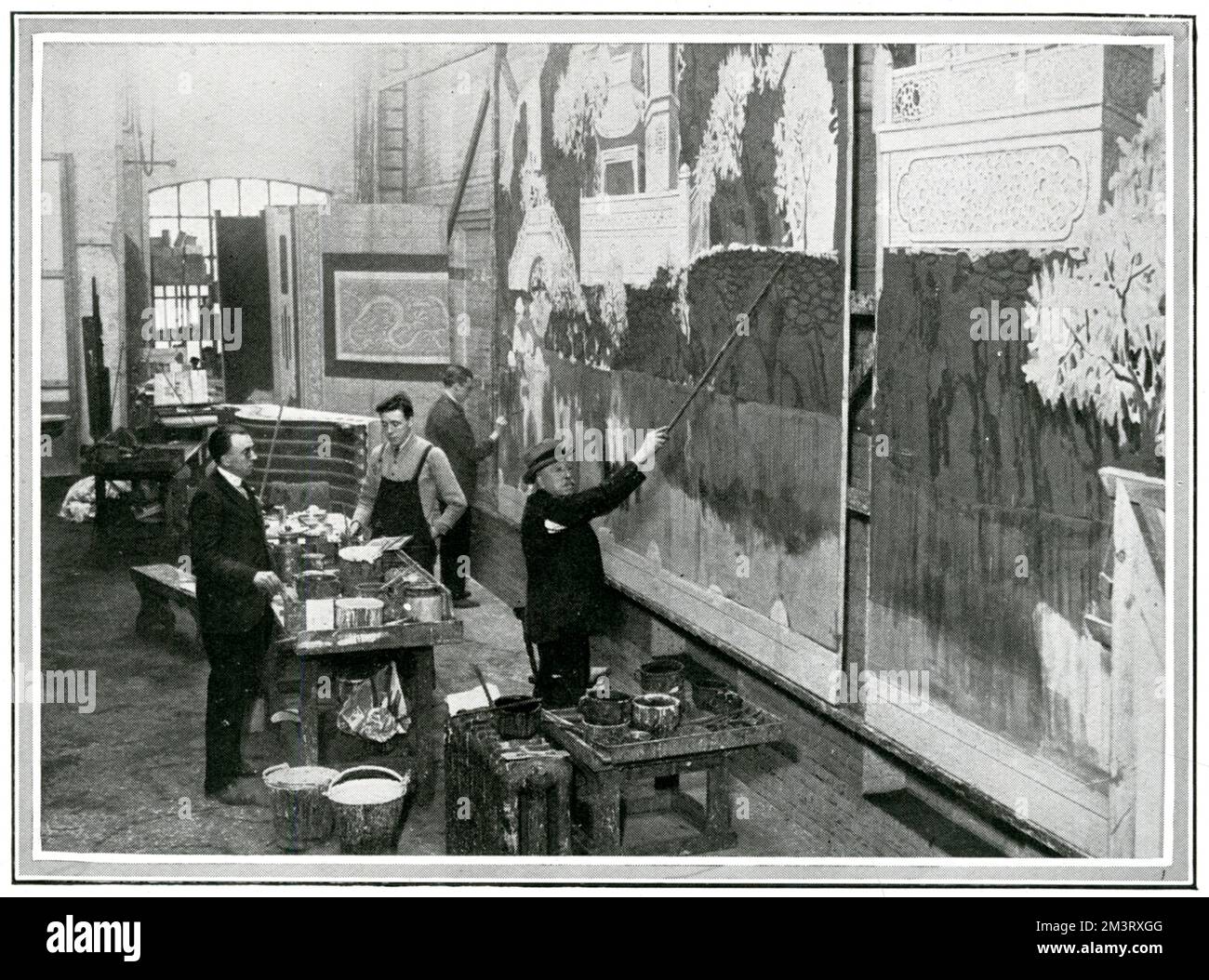 Famoso pittore scenografico, Joseph Harker, visto nel suo studio con uno dei suoi quattro figli. Harker è stata la principale azienda per la pittura di paesaggio nel mondo del teatro londinese. Data: 1924 Foto Stock
