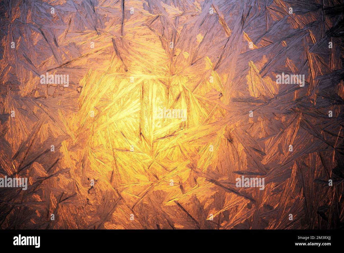Sfondo di Natale con motivo congelato sul vetro della finestra. Luce dell'alba che illumina la finestra ghiacciata. La vera consistenza del gelo invernale Foto Stock