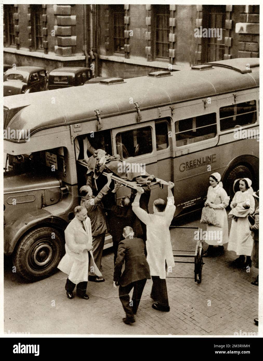 Paziente dell'ospedale di Bart sollevato su una barella in un allenatore ospedaliero Green Line appositamente attrezzato. Come parte dei preparativi per la guerra, molti autobus sono stati inviati fuori dagli ospedali e convertiti in ambulanze per evacuare i pazienti in caso di incursioni aeree, con sedili sostituiti da scaffali per trasportare barelle. Data: 1939 Foto Stock