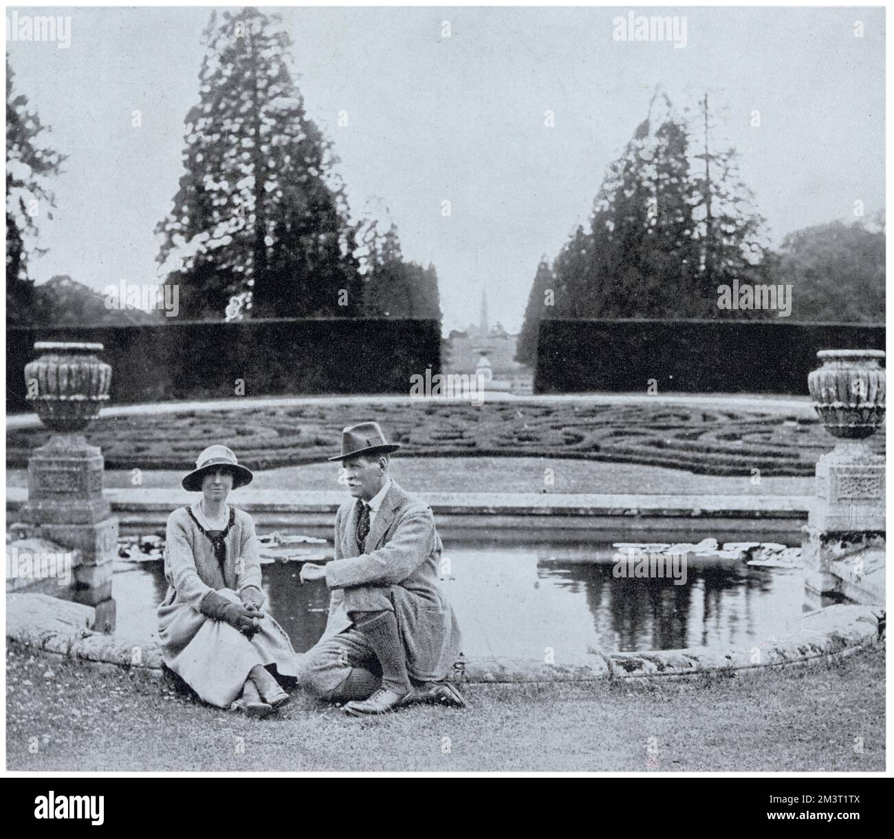Charles Rouse-Boughton-Knight, con sua moglie, la prima, Helen Dupre, seduto accanto al laghetto nel terreno della loro casa, Downton Castle, in Herefordshire. Foto Stock