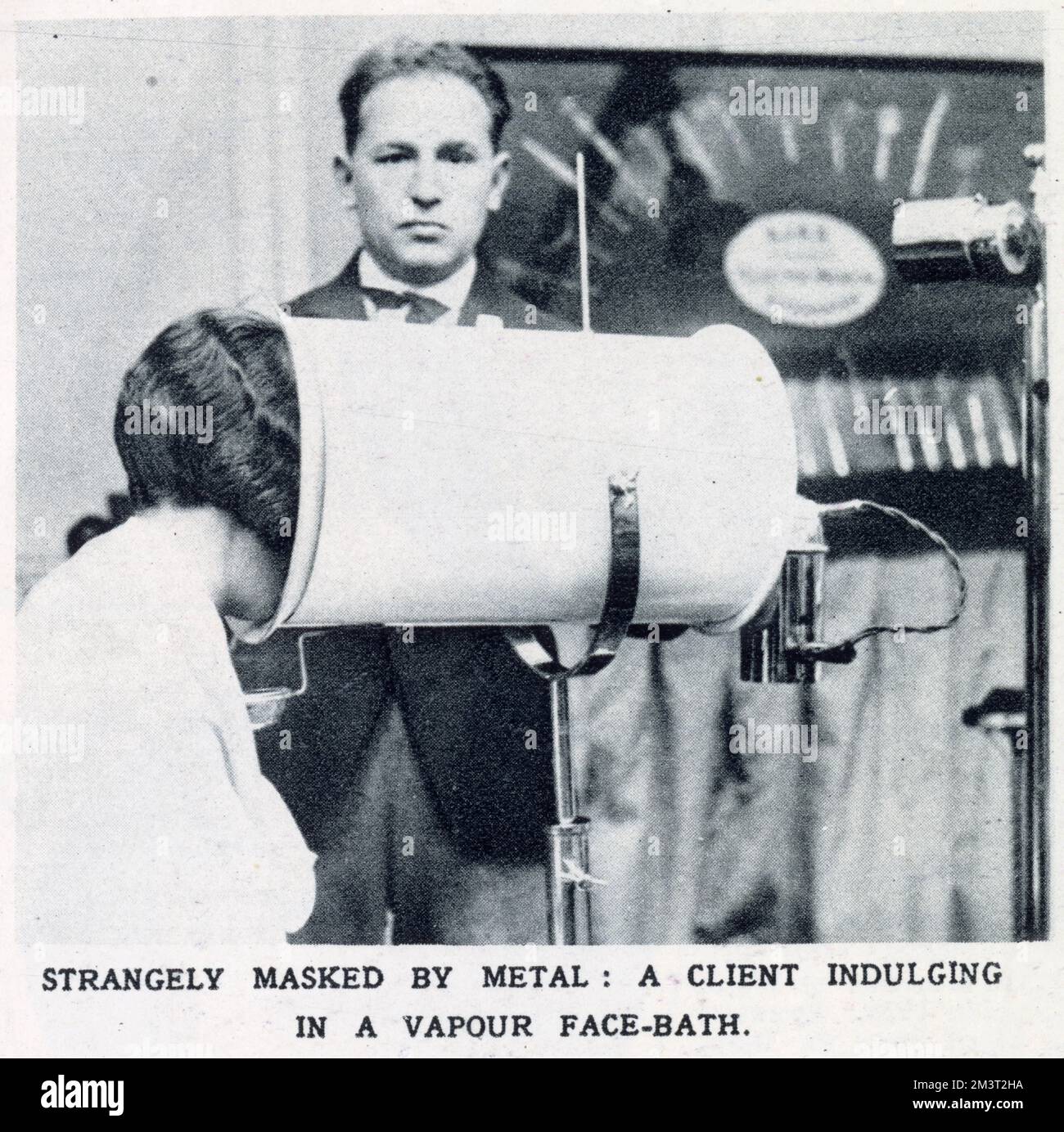 Stranamente mascherato da Metal: Un cliente che indulge in un bagno a vapore, esposto alla Fiera annuale dei parrucchieri. Data: 1928 Foto Stock